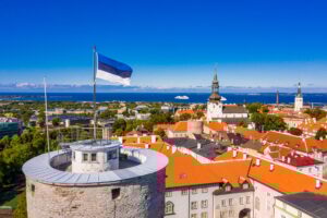 Flag of Estonia on the Tall Hermann Tower under the sunlight and a blue sky in Tallinn