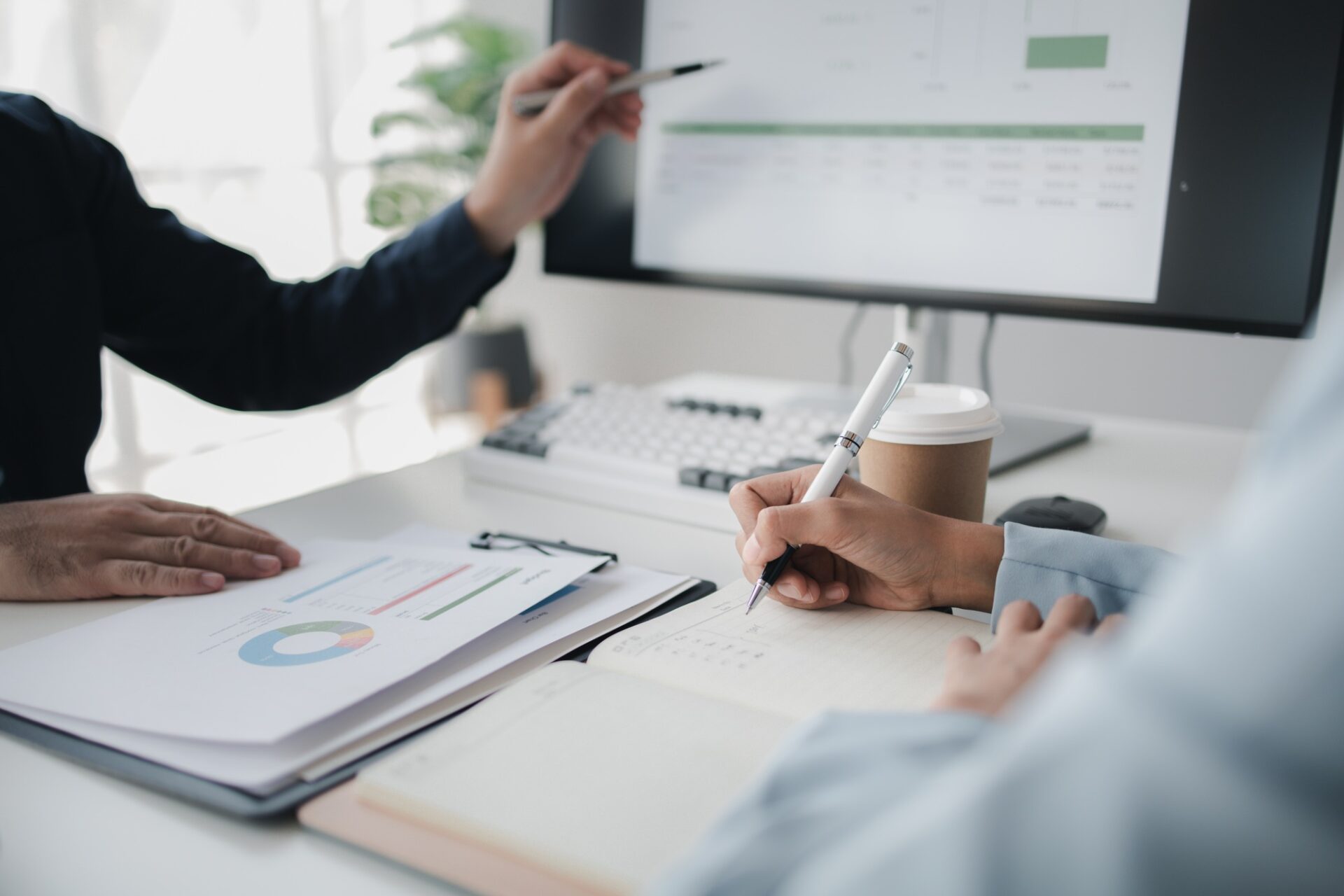 Two people looking at datasheets of marketing and sales results, analysis of business results jointl
